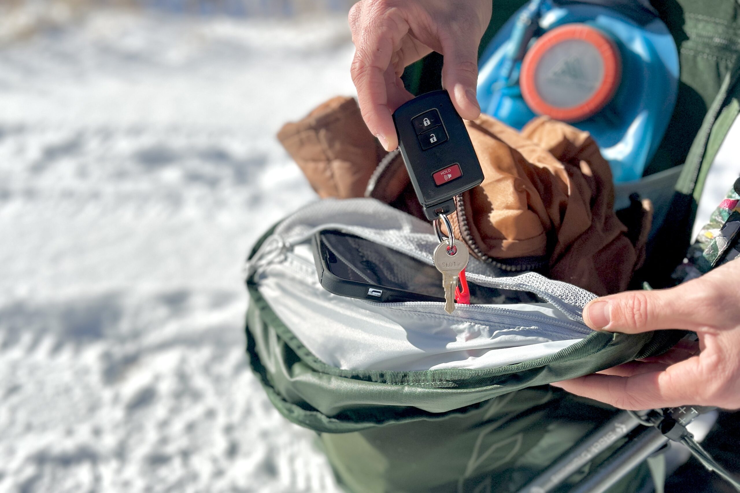 Close up of a person pulling out the keys - attached to the internal key clip - on a daypack.