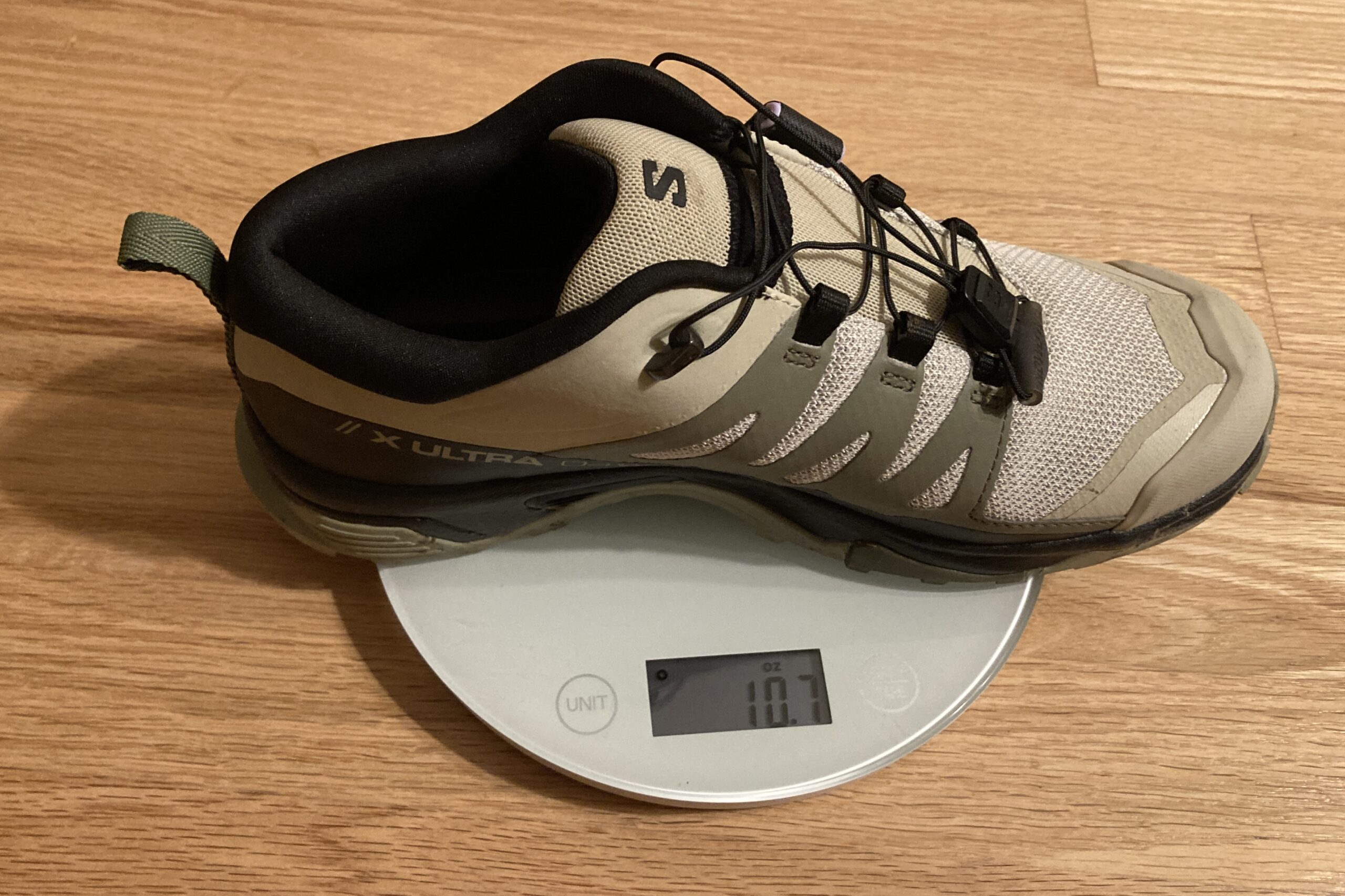 Close up showing a hiking shoe on a kitchen scale. It reads 10.7 ounces.