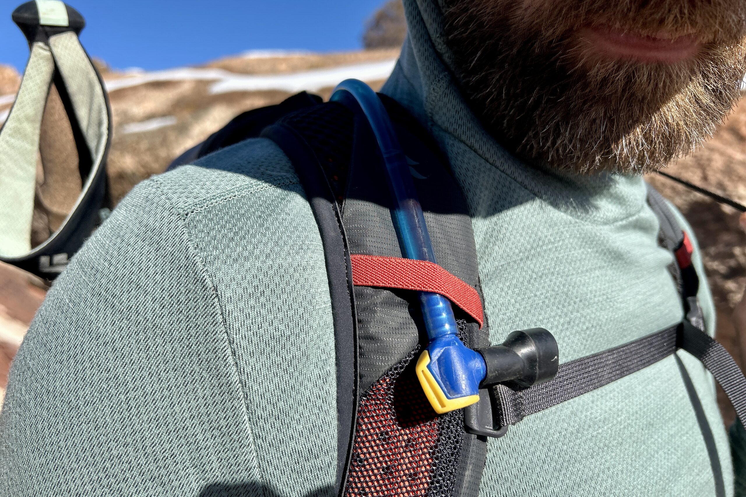 Close up of a hydration tube routed through a shoulder strap for easy access.