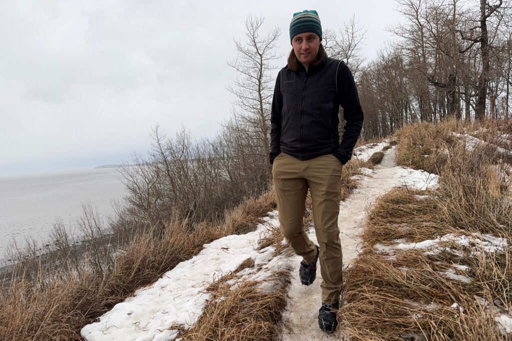 A man walks along a trail on a oceanside bluff.