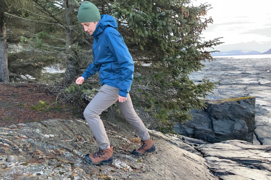 A man hikes along a rocky coastline.