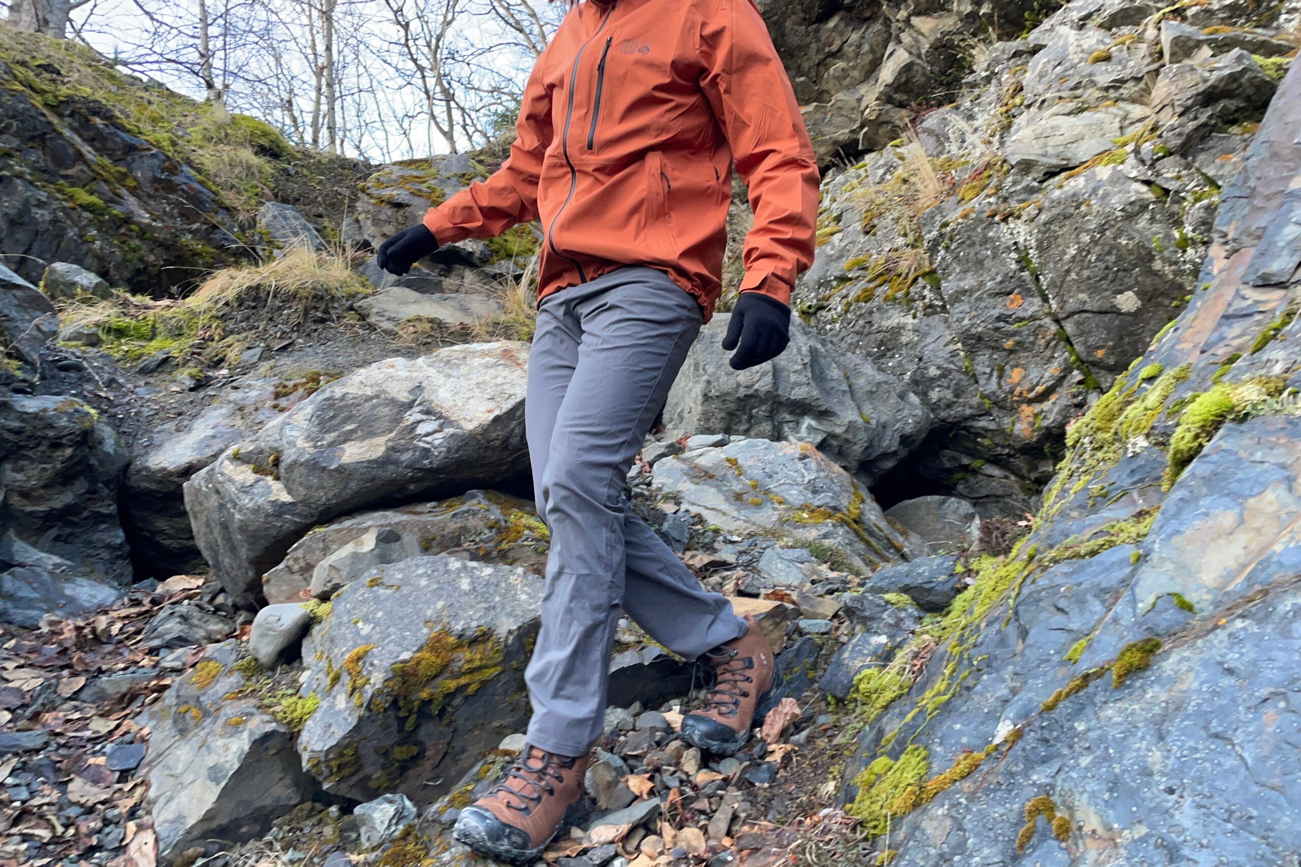 A man walks down a steep, rocky hill.