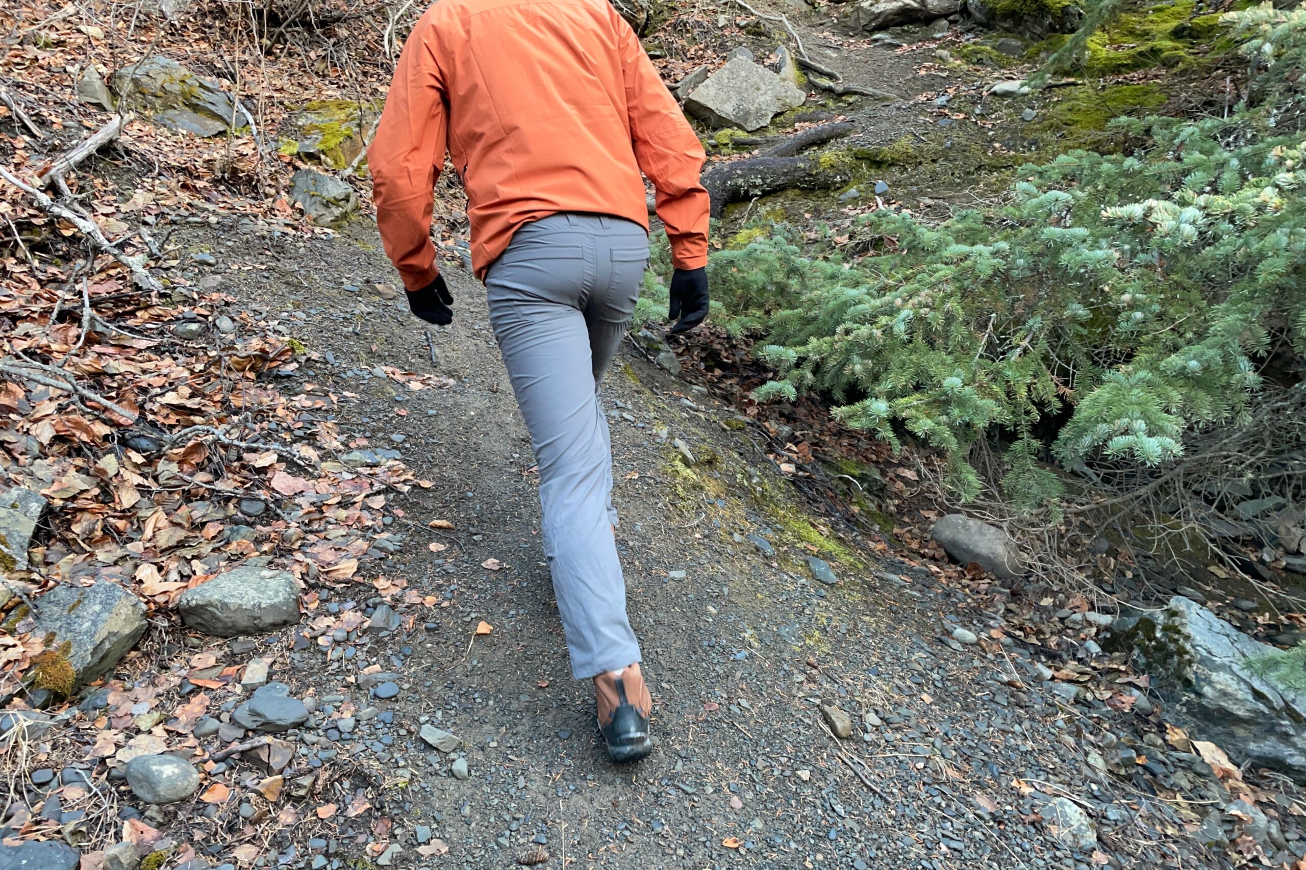 A closeup of the rear of hiking pants as a man hikes uphill.