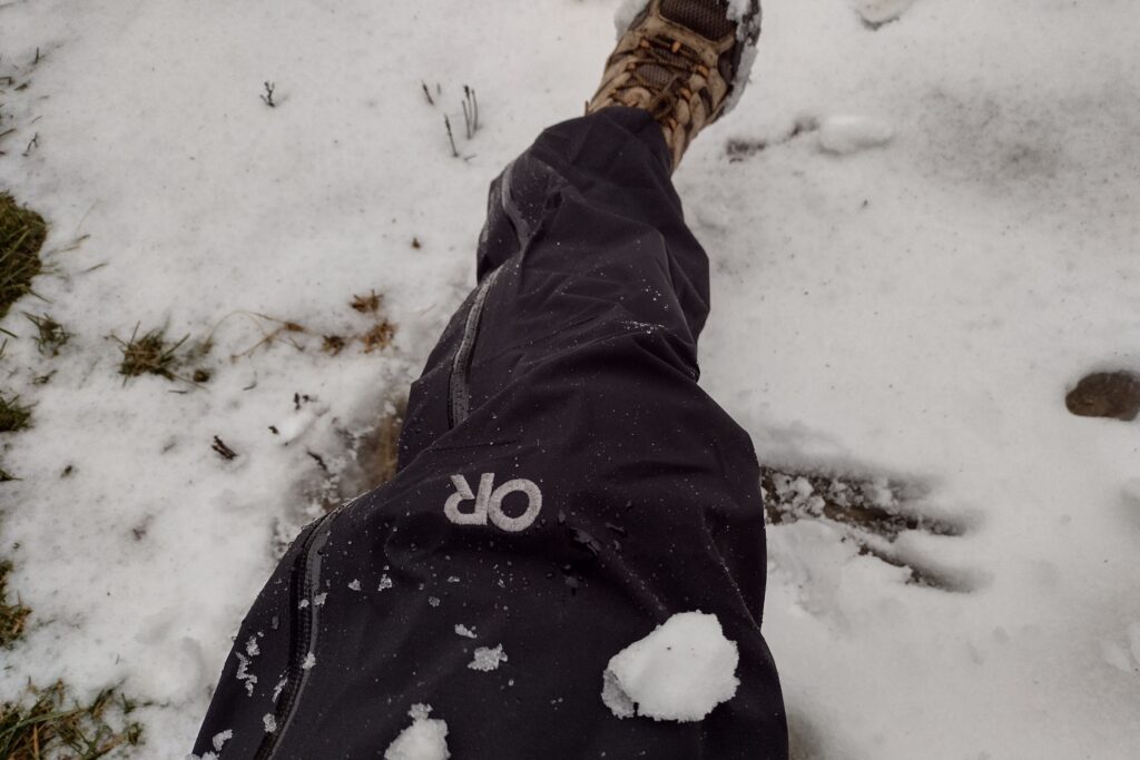 Closeup of someone wearing the Outdoor Research Foray pants on a snowy trail.