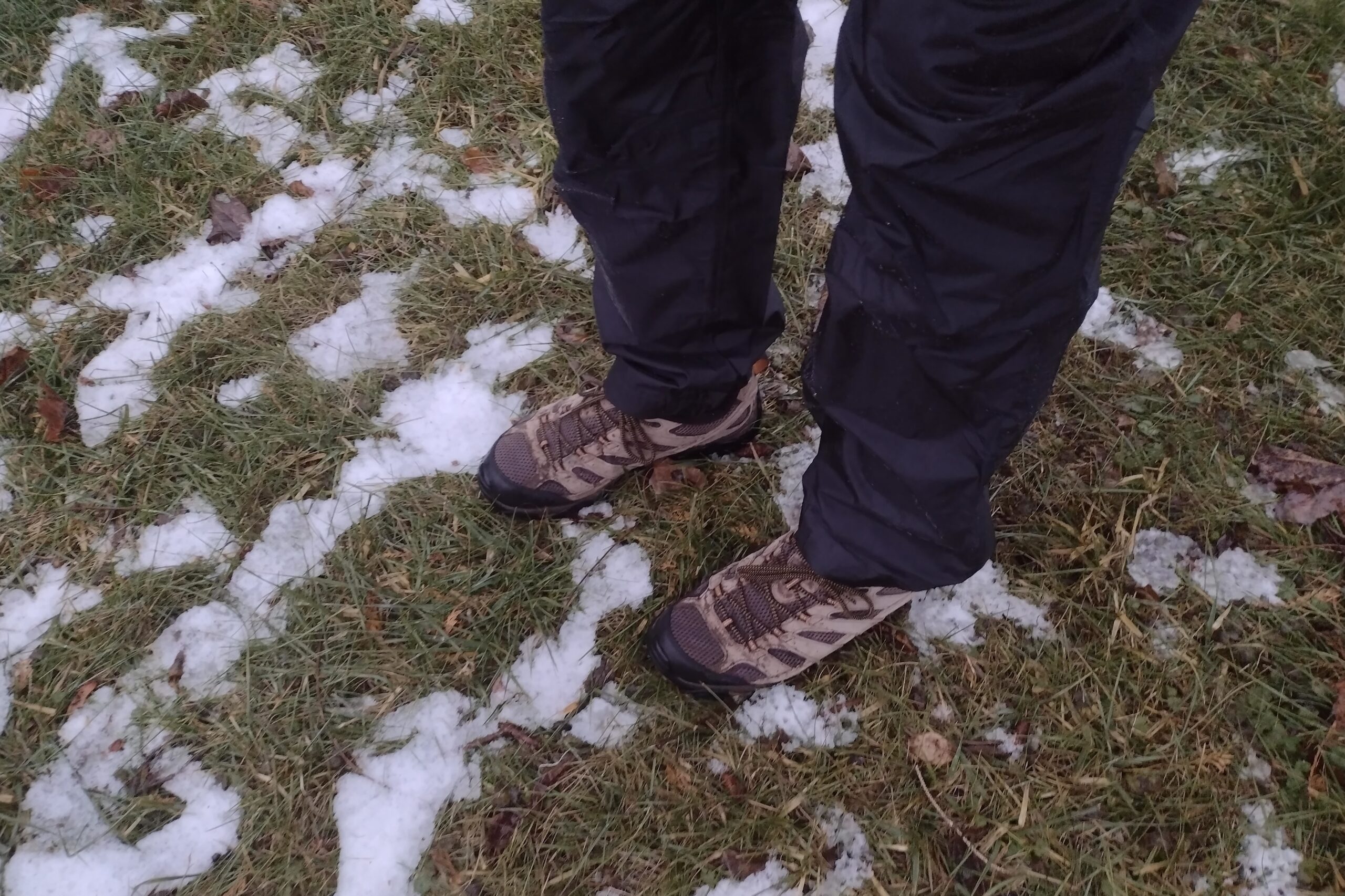 Closeup of someone wearing the Outdoor Research Helium rain pants.