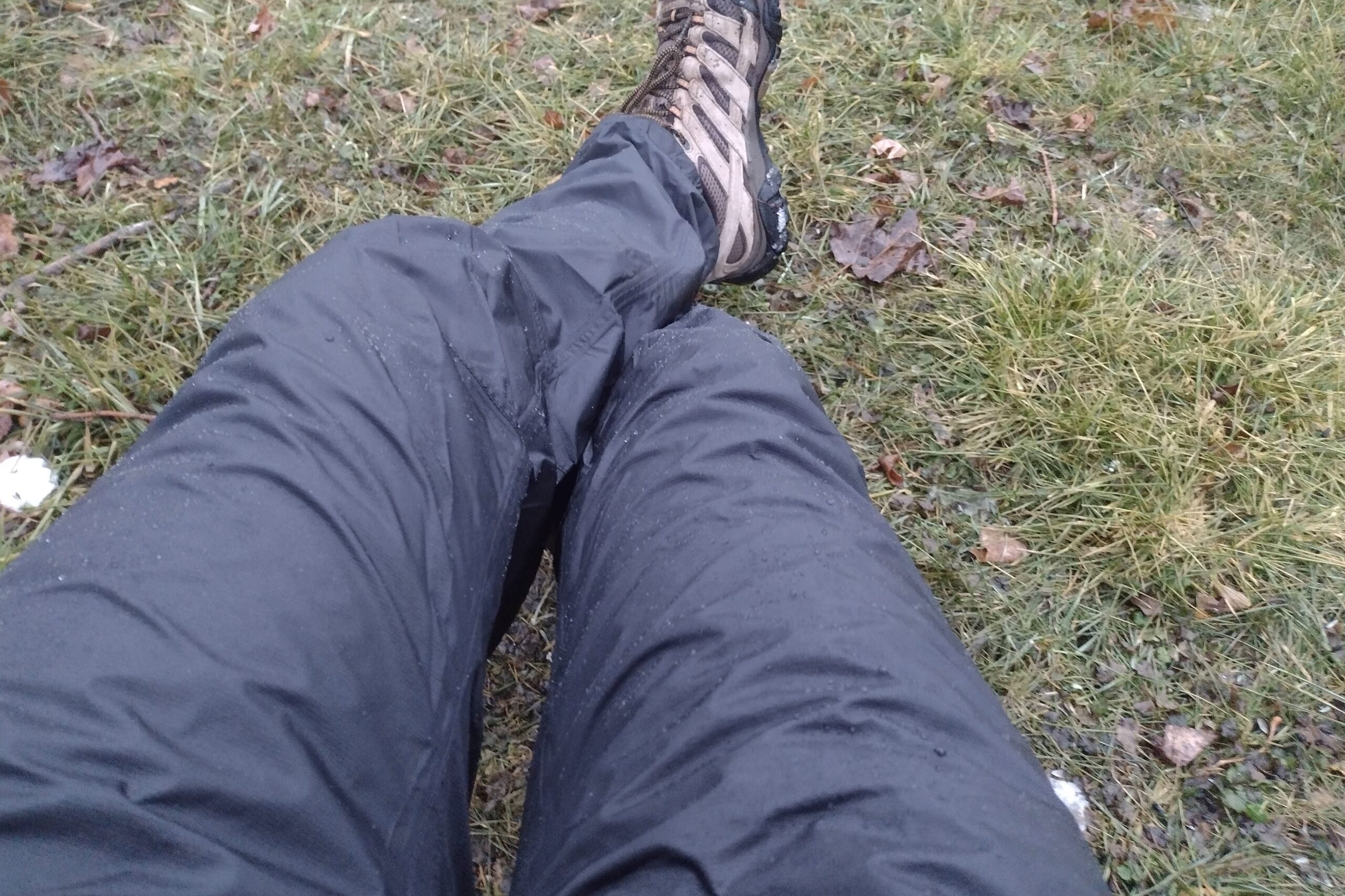 Closeup of someone wearing the Outdoor Research Helium rain pants.