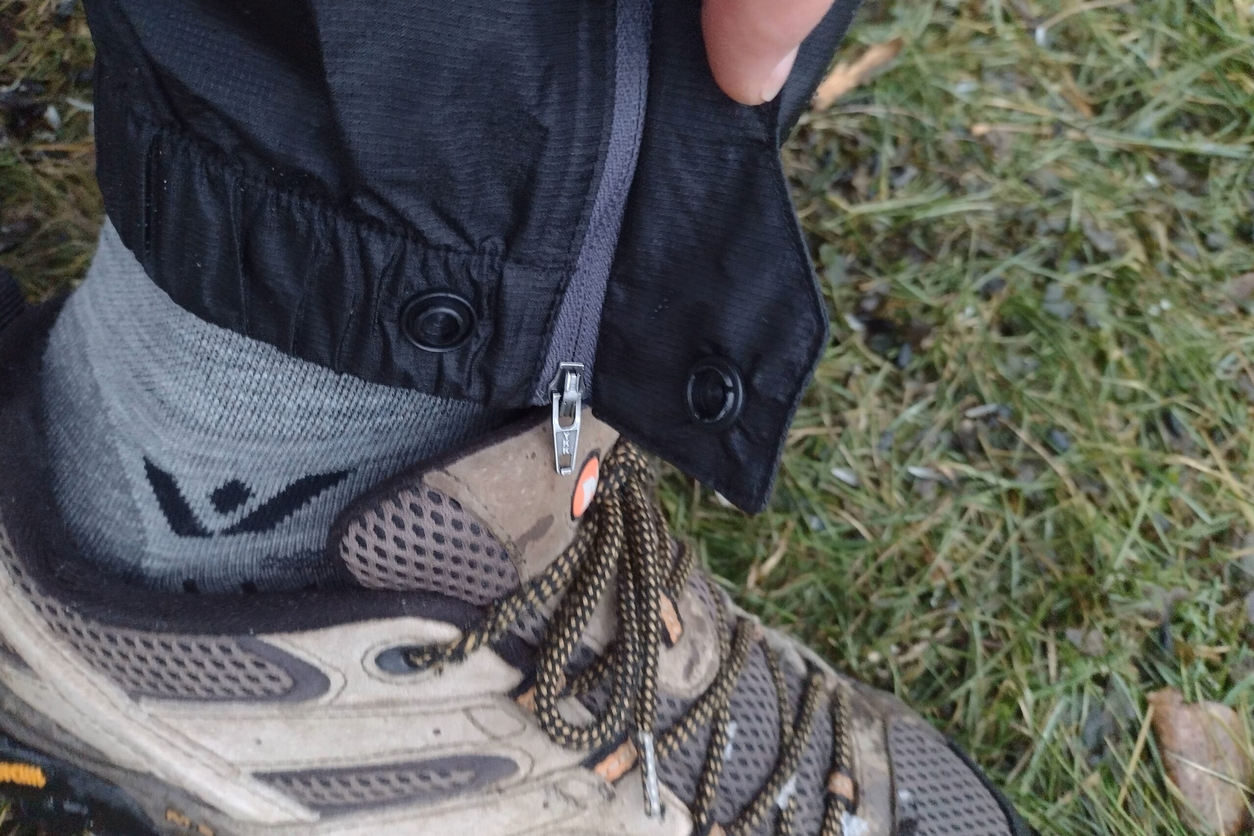 Closeup of the ankle zipper and snap on the Outdoor Research Helium rain pants.