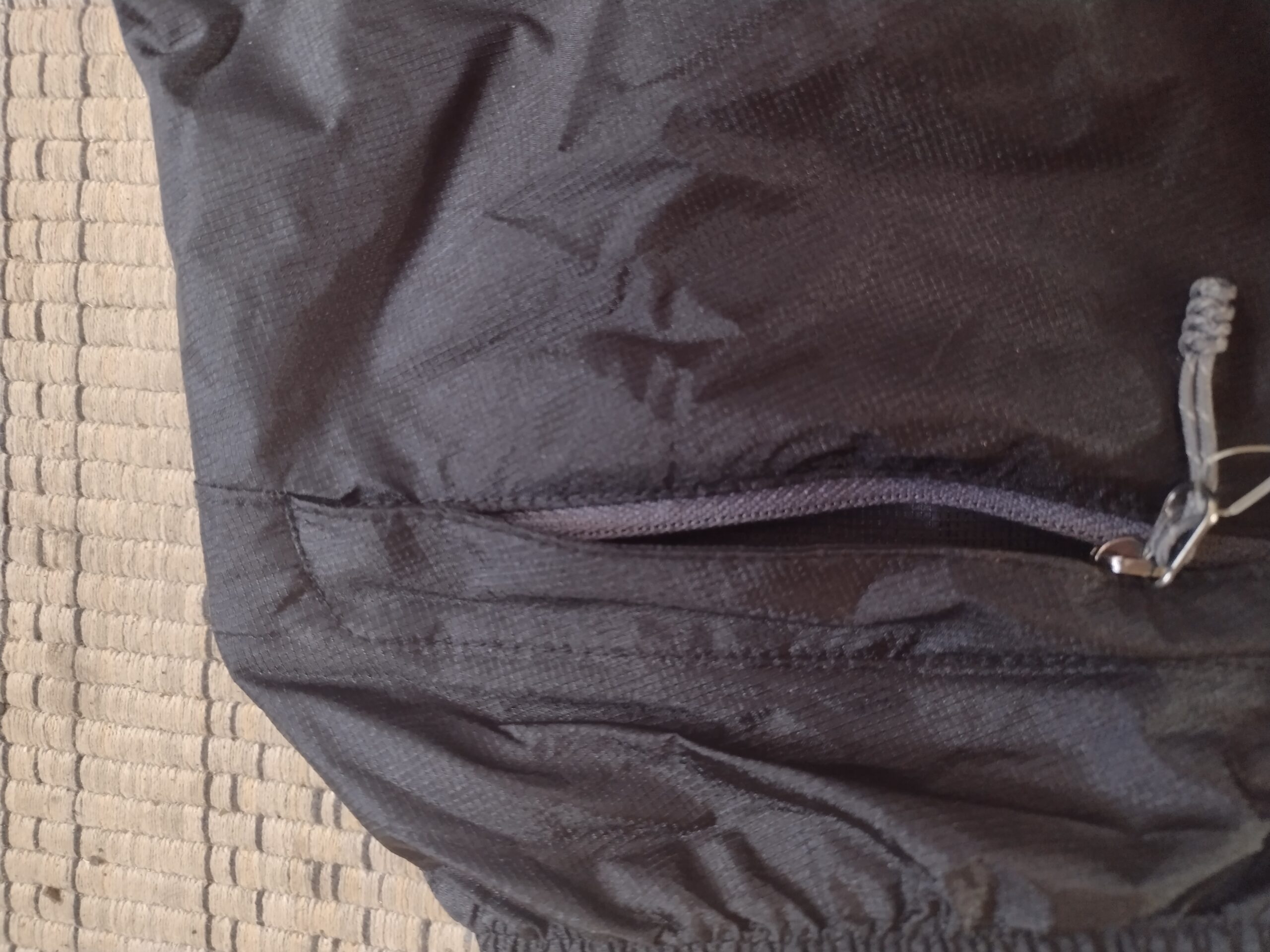 Closeup of a pocket zipper on the Outdoor Research Helium rain pants.