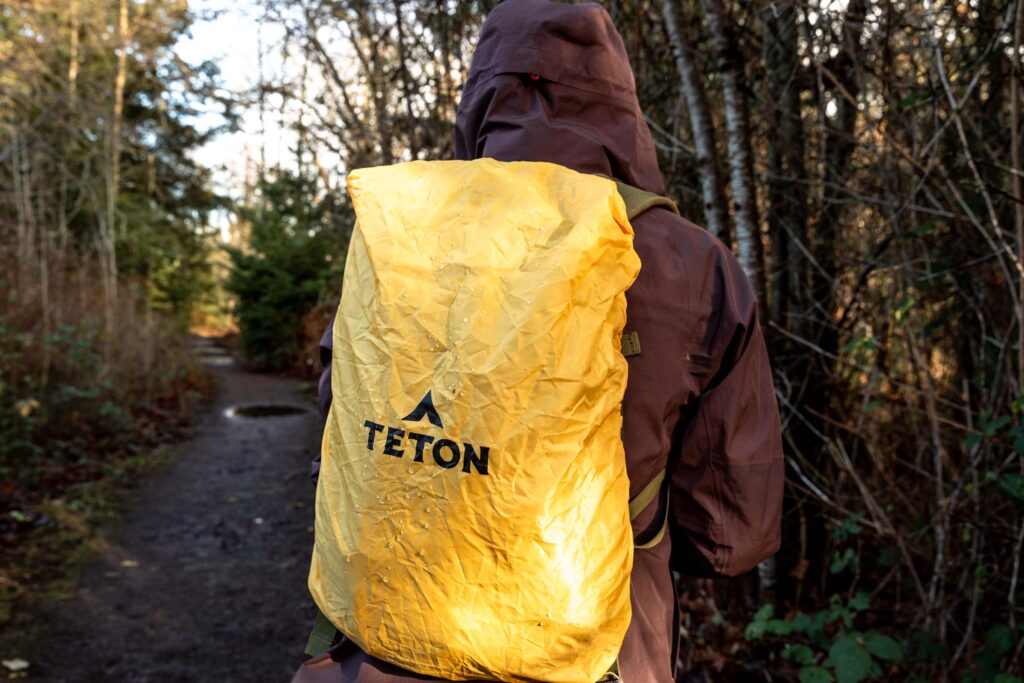 Details of TETON Sports Oasis 18L Hydration Pack - a person is wearing the pack with the pack cover