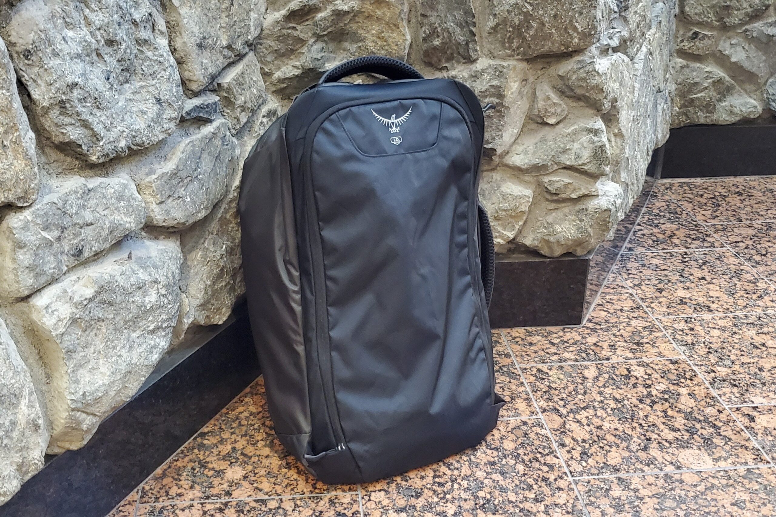 A travel backpack leans against a corner.