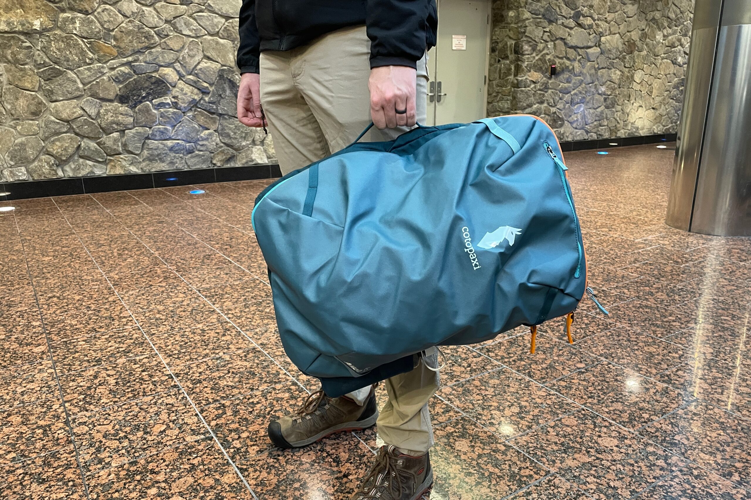 A closeup of a backpack being carried as a duffel.