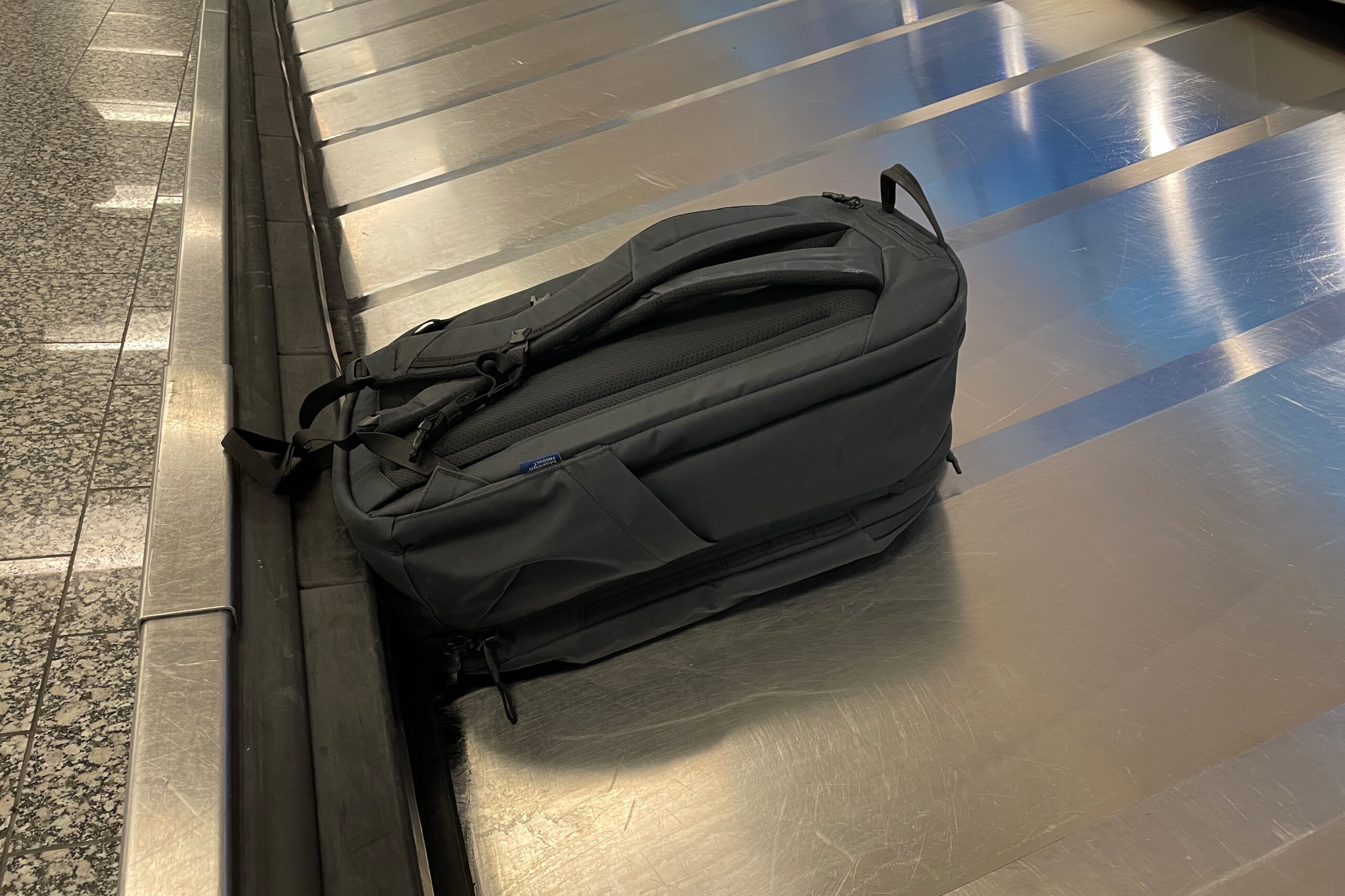 A backpack sits on a baggage carousel.