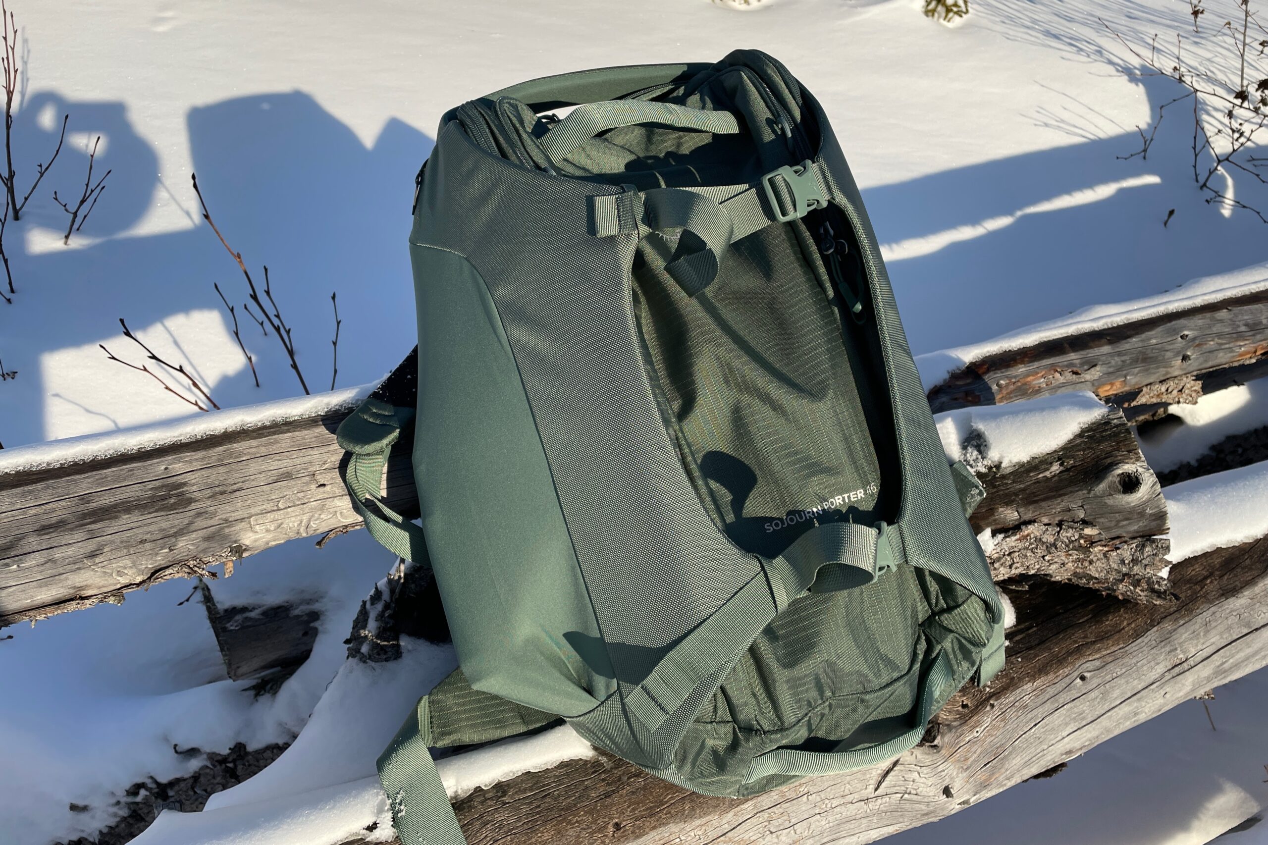 A backpack rests on a wooden fence